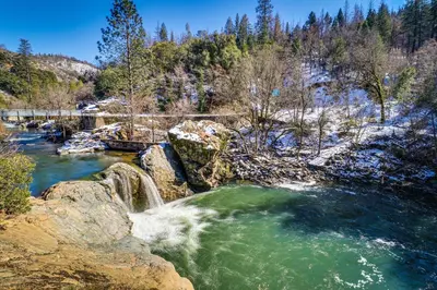 a waterfall in a river with rocks and trees at Restoration House in Groveland