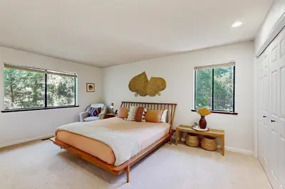 a bedroom with a bed and two windows at Restoration House in Groveland