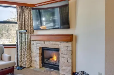 a living room with a fireplace with a tv above it at Ski-InandSki-Out and Mtn Views! Everline Resort Condo in Olympic Valley