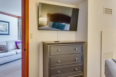 a room with a dresser with a tv on top at Ski-InandSki-Out and Mtn Views! Everline Resort Condo in Olympic Valley