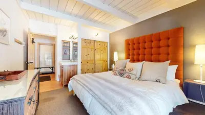 a bedroom with a large bed and a bathroom at Villa de los Pinos #09 condo in Mammoth Lakes