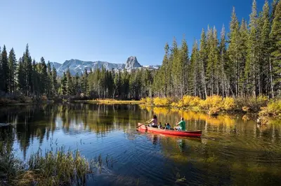 two people in a red canoe on a lake at Villa de los Pinos #09 condo in Mammoth Lakes