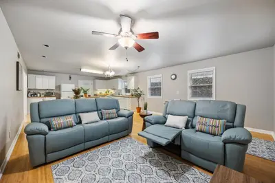 a living room with two blue couches and a ceiling fan at Midtown Apartment with Private Parking and King Bed in Sacramento