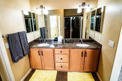 a bathroom with two sinks and a large mirror at Eat-Sleep-Stroll-Repeat! Walkable Midtown 2BR Home in Reno
