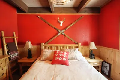 a bedroom with a bed with a clock on the wall at HNC0628 - Stagecoach Escape condo in Stateline