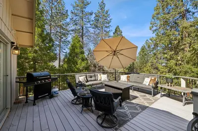 a patio with a grill and a table and chairs at Whispering Pines Retreat home in Groveland