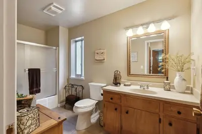 a bathroom with a toilet and a sink and a mirror at Whispering Pines Retreat home in Groveland