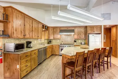 a kitchen with wooden cabinets and a large island at Yosemite's Riverfront Retreat in Wawona