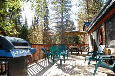a deck with chairs and a grill and a table and chairs at 9N Fox Hollow in Wawona
