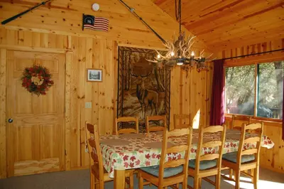 a dining room with a table and chairs in a cabin at 9N Fox Hollow in Wawona