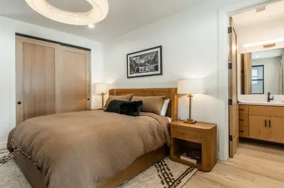 a bedroom with a large bed and a sink at New Luxury 4BR /3BA Obsidian Reserve #110 – Hot Tub, 2-Car Garage, Pool Table, Mount Views! in Mammoth Lakes
