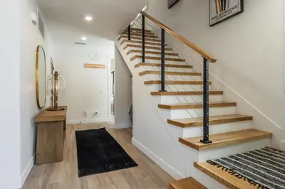 a staircase in a home with white walls and wooden floors at New Luxury 4BR /3BA Obsidian Reserve #110 – Hot Tub, 2-Car Garage, Pool Table, Mount Views! in Mammoth Lakes