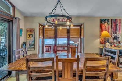 a dining room with a wooden table and a chandelier at The Lazy Bear Northstar Resort Truckee in Truckee
