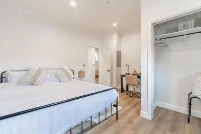 a white bedroom with a bed and a desk at Stylish 2-Bedroom walking distance to Downtown in Reno