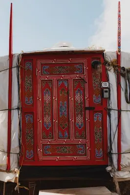 a red door on the side of a truck at Mongolian yurt at a nature retreat in Miramonte