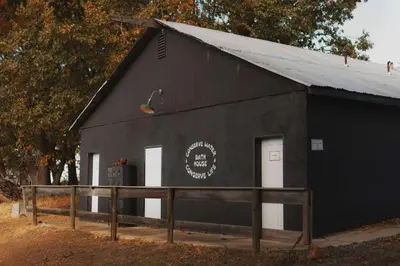 a black building with two white doors on it at Mongolian yurt at a nature retreat in Miramonte