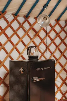 a black refrigerator with a tea kettle on top of it at Cosy yurt at a nature retreat in Sequoia N Forest in Miramonte