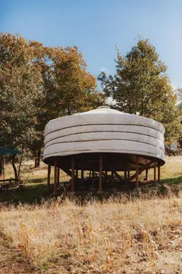 a large round building in the middle of a field at Cosy yurt at a nature retreat in Sequoia N Forest in Miramonte