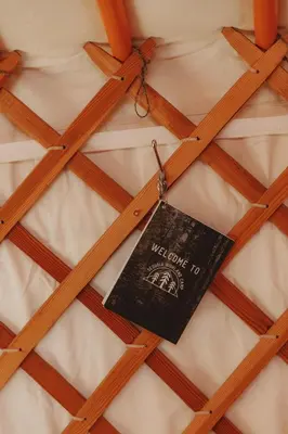 a welcome to sign hanging on top of a bed at Cosy yurt at a nature retreat in Miramonte