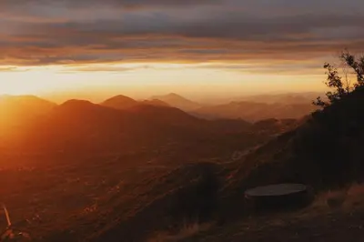 a view of a mountain range with the sun setting at Cosy yurt at a nature retreat in Miramonte