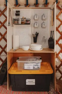 a shelf with bowls and other items on it at Glamping yurt at a nature retreat near Sequoia in Miramonte