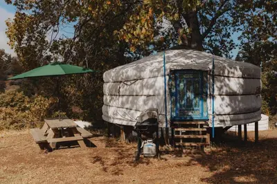 a dome tent with a picnic table and an umbrella at Glamping yurt at a nature retreat near Sequoia in Miramonte