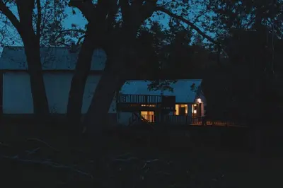a house lit up at night in the dark at Secluded rustic 2-bedroom cabin on nature retreat in Miramonte