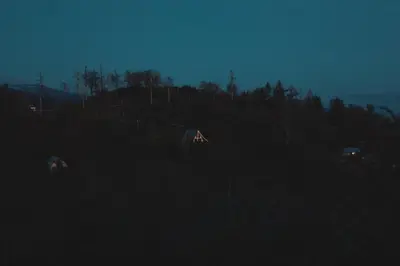 a group of houses in a field at night at Secluded rustic 2-bedroom cabin on nature retreat in Miramonte