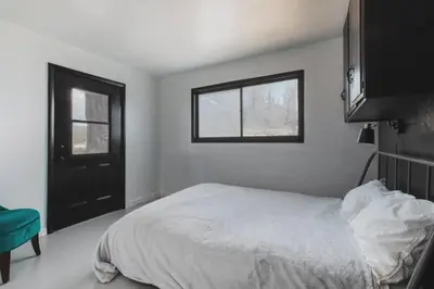 a white bedroom with a bed and a window at Spacious 4-bedroom cabin on secluded private land in Miramonte