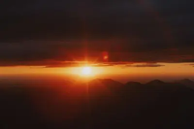 a sunset with the sun setting over the mountains at Spacious 4-bedroom cabin on secluded private land in Miramonte