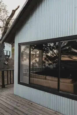a building with a window on the side of it at Secluded rustic 2-bedroom cabin at nature retreat in Miramonte