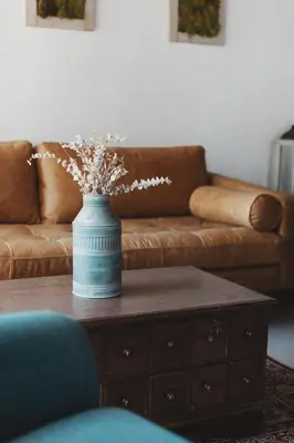 a blue vase on a coffee table in a living room at Secluded rustic 1-bedroom cabin on private land in Miramonte