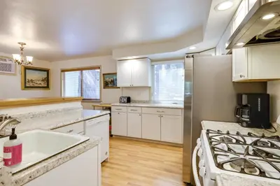 a kitchen with white cabinets and white appliances at Stay Near Big Trees, Bring Your Pets Arnold Cabin in Arnold
