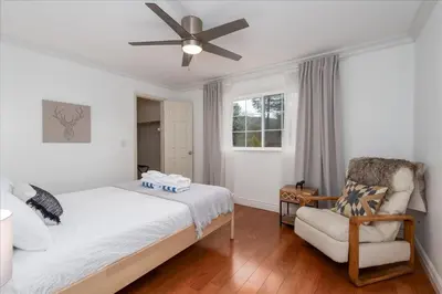 a bedroom with a bed and a chair and a ceiling fan at New Big Sky Cabin at Yosemite w/ VIEWS, hot tub, firepit, and more in Oakhurst