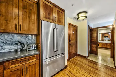 a kitchen with wooden cabinets and a stainless steel refrigerator at Pinnacle Stateline Resort BBQ Hot Tub Pool Zalanta 214 in Stateline