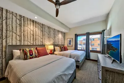 a bedroom with two beds and a flat screen tv at Pinnacle Stateline Resort BBQ Hot Tub Pool Zalanta 214 in Stateline