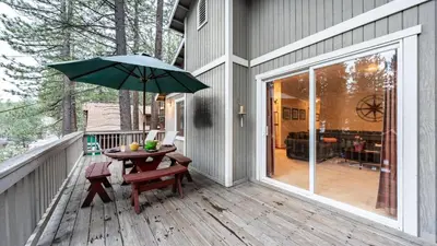 a patio with a table and an umbrella on a porch at Stylish Truckee Retreat Deck Near Lake Skiing Moraine by AvantStay in Truckee