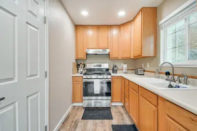 a kitchen with wooden cabinets and a stove and a sink at Coulterville Home with Gazebo Near Lakes and Hiking! in Coulterville