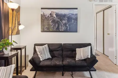 a leather couch in a living room with a painting on the wall at Lincoln Lodge cabin in Groveland