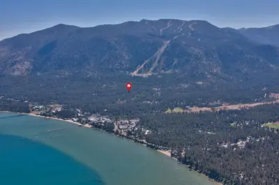 a red balloon flying over the water next to a mountain at HCH1475 - Heavenly Lake View Retreat home in South Lake Tahoe