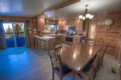 a kitchen with a wooden table and a dining room at HCH1475 - Heavenly Lake View Retreat home in South Lake Tahoe