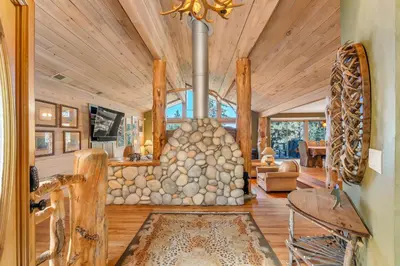 a living room with a large stone fireplace at HCH1239 - Heavenly Tree House home in South Lake Tahoe