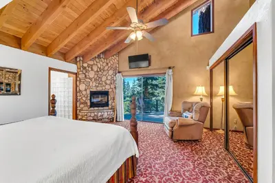 a bedroom with a bed and a chair and a window at HCH1239 - Heavenly Tree House home in South Lake Tahoe