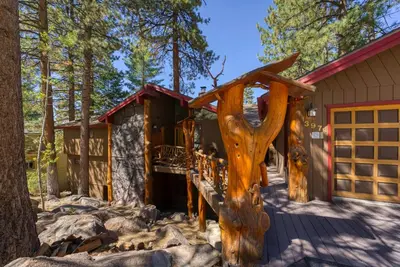 a log cabin with a tree trunk in front of it at HCH1239 - Heavenly Tree House home in South Lake Tahoe