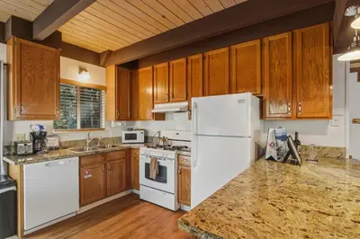 a kitchen with wooden cabinets and a white refrigerator at COH0885 - Skyline Divine home in South Lake Tahoe