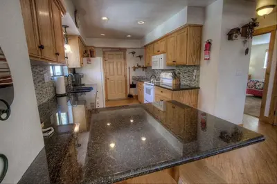 a kitchen with a granite counter top and wooden cabinets at HCH1217 - Pinehill Ponderosa home in South Lake Tahoe