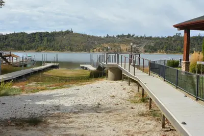 a walkway leading to a dock on a lake at Deer Lodge #1 Lake front in Bass Lake