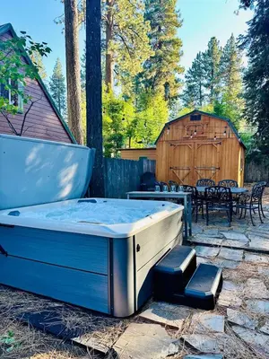 a hot tub sitting on a patio with a table at CYH0876 - Island Cabin cabin in South Lake Tahoe