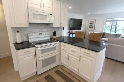 a kitchen with white cabinets and black counter tops at LVC0615 - Lake Therapy condo in Zephyr Cove