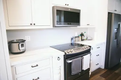 a kitchen with a stove and a microwave at A Luxury Yosemite Retreat in Mariposa